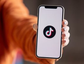 main tenant un smartphone avec l'application TikTok