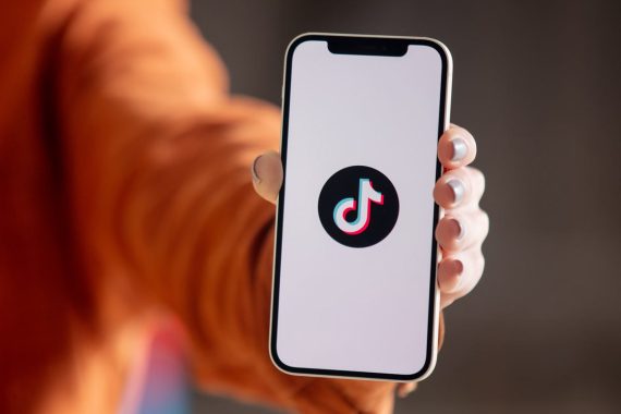 main tenant un smartphone avec l'application TikTok